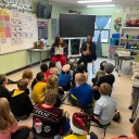 App State Chief Diversity Officer, Jamie Parson, left in background, and App State alumnus Hudson Miller ’21, right in background, read “First Rain” to students at the App State Academy at Elkin in December 2022. The reading was a celebration of Jewish heritage. Miller was the former president of App State’s Jewish fraternity, Alpha Epsilon Pi. Photo submitted